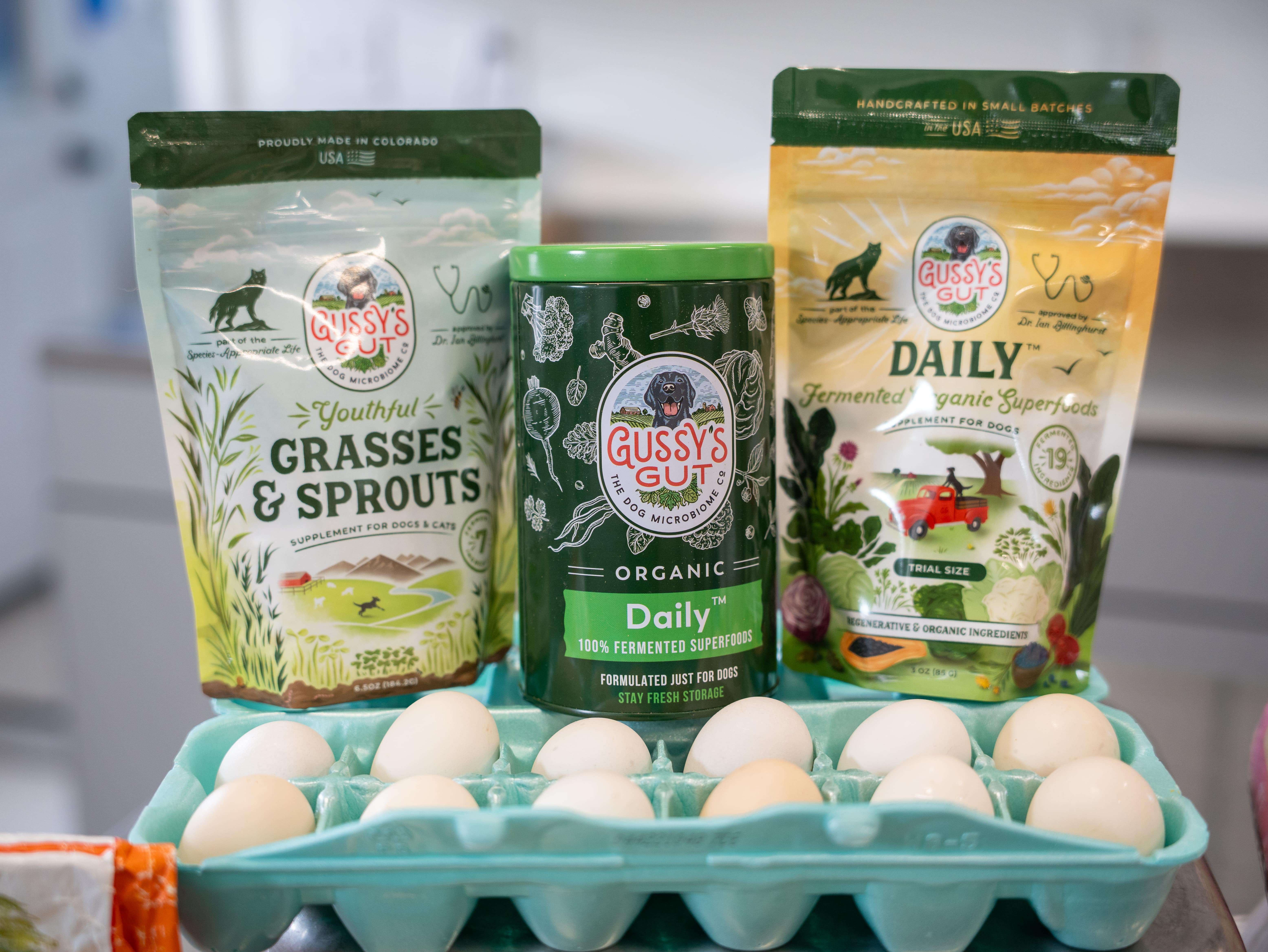 Gussy's Gut supplements on a counter top with a carton of eggs