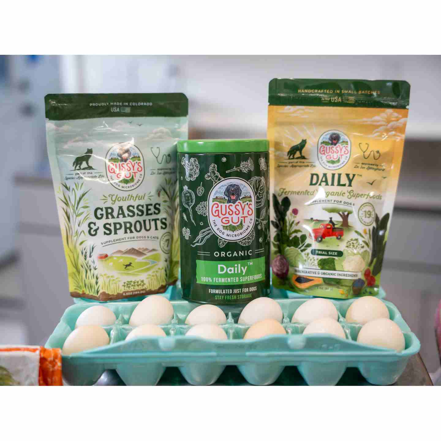 Gussy's Gut supplements on a counter top with a carton of eggs